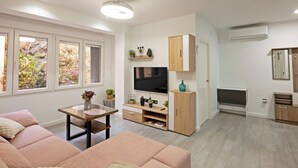 Ett modernt vardagsrum med en soffa, en tv och ett underhållningscenter.