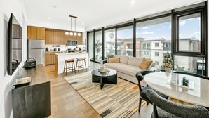 Un apartamento moderno con cocina, sala de estar y ventanas amplias que ofrecen vista a la ciudad.