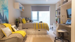 Une chambre à coucher moderne avec un lit, un bureau et une chaise.