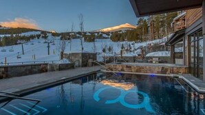 A pool with a ski slope view, stone steps, and a wooden deck. - Luxury 1-Bedroom Condo at Grand Colorado on Peak 8 — Ski-In/Ski-Out! (Breckenridge)