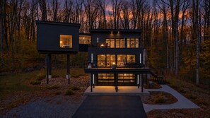 A modern two-story house with a balcony, surrounded by trees. - Luxury tree house inspired house located 5 miles from Ellicottville, NY (Salamanca)
