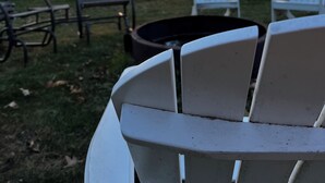 A sunset view with a fire pit and Adirondack chairs in a grassy area. - 8 Acre Lower-Level Hobby Farm Getaway (Prior Lake)