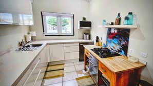 Cocina compacta con ventana, microondas, tostadora y estufa.