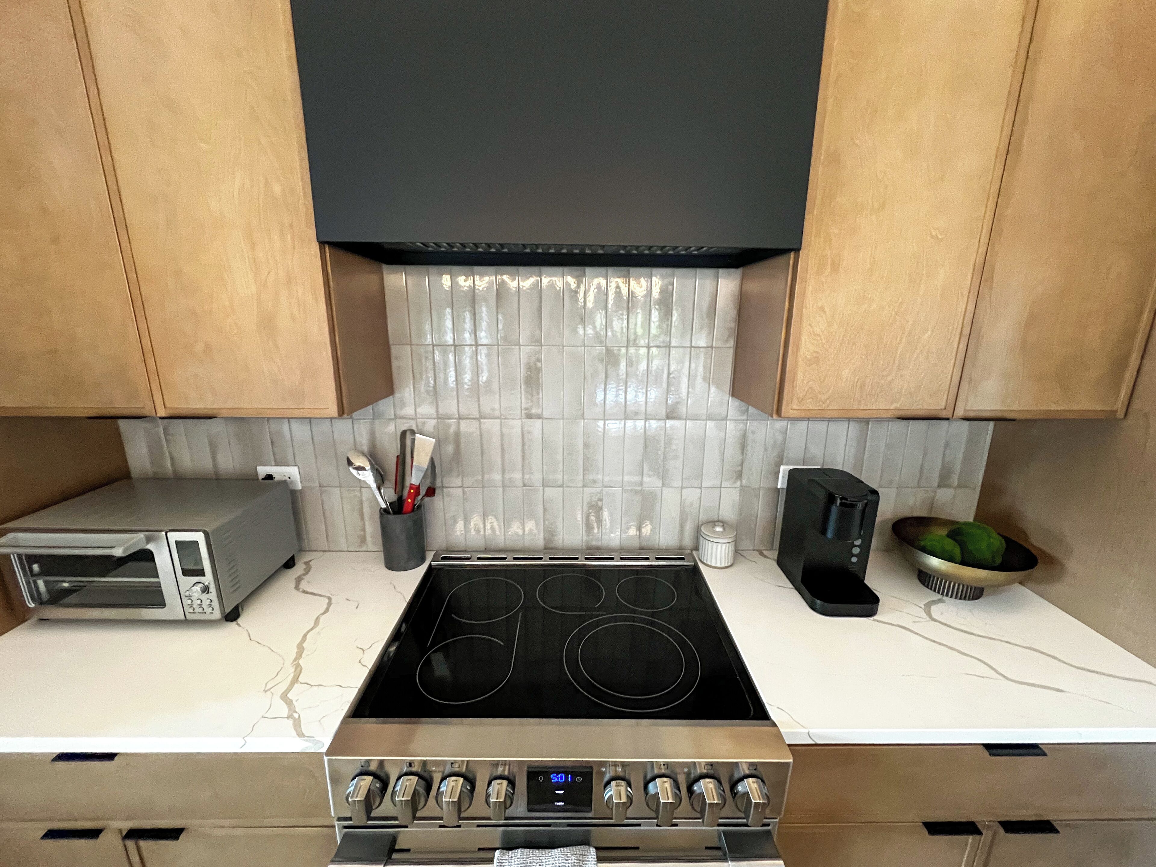 Una cocina equipada con horno empotrado, microondas, cocina y cafetera.