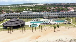 Un resort con una piscina grande, un edificio circular y una zona de playa.