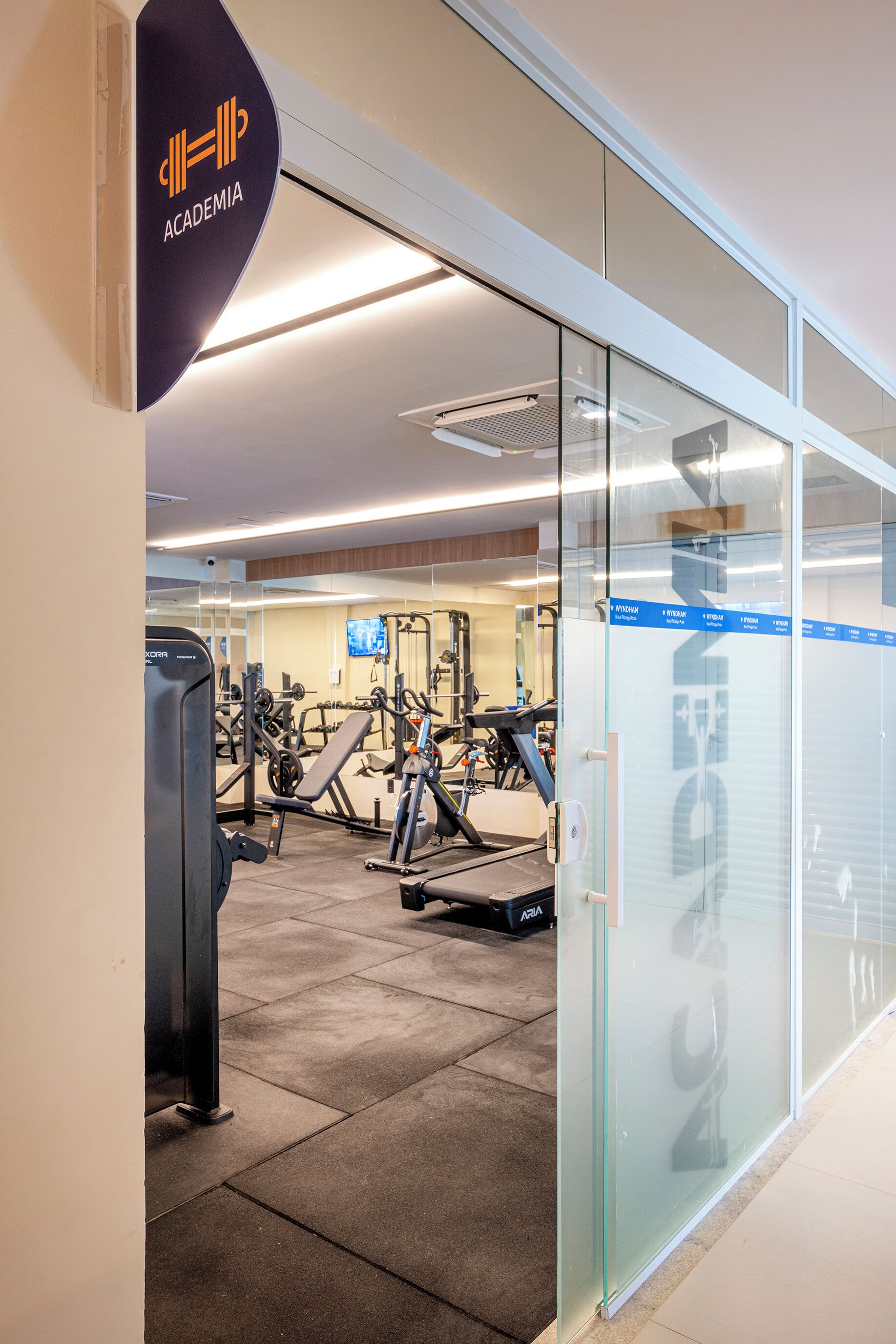 A gym with exercise equipment and a sign that reads "ACADEMIA".