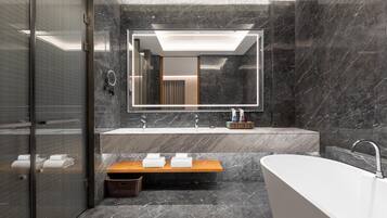 A modern bathroom with a large mirror, two sinks, a bathtub, and a wooden bench.