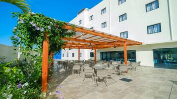 Een buitenzwembad, parasols voor strand/zwembad