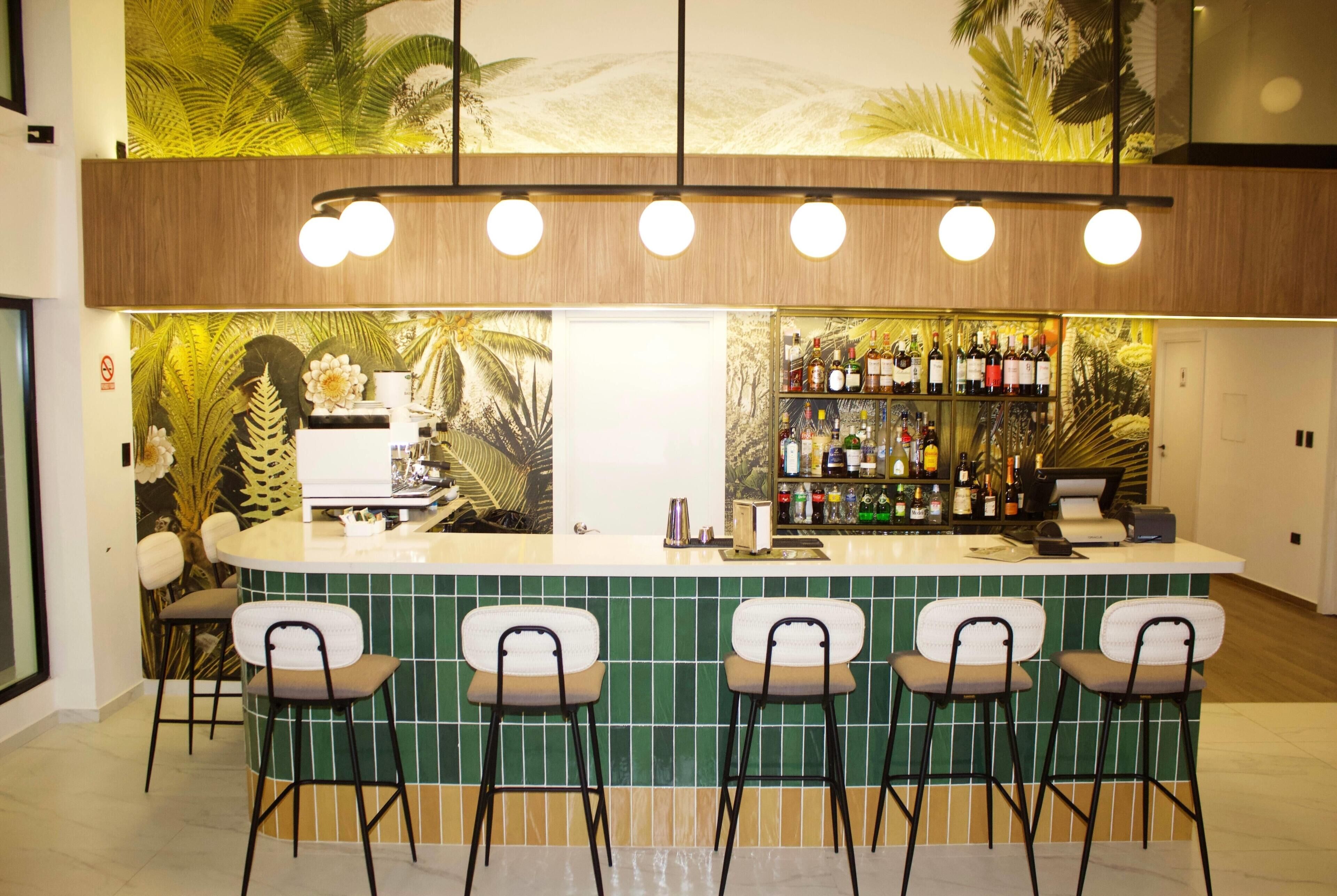 A bar area with a counter, bar stools, and a shelf of bottles.