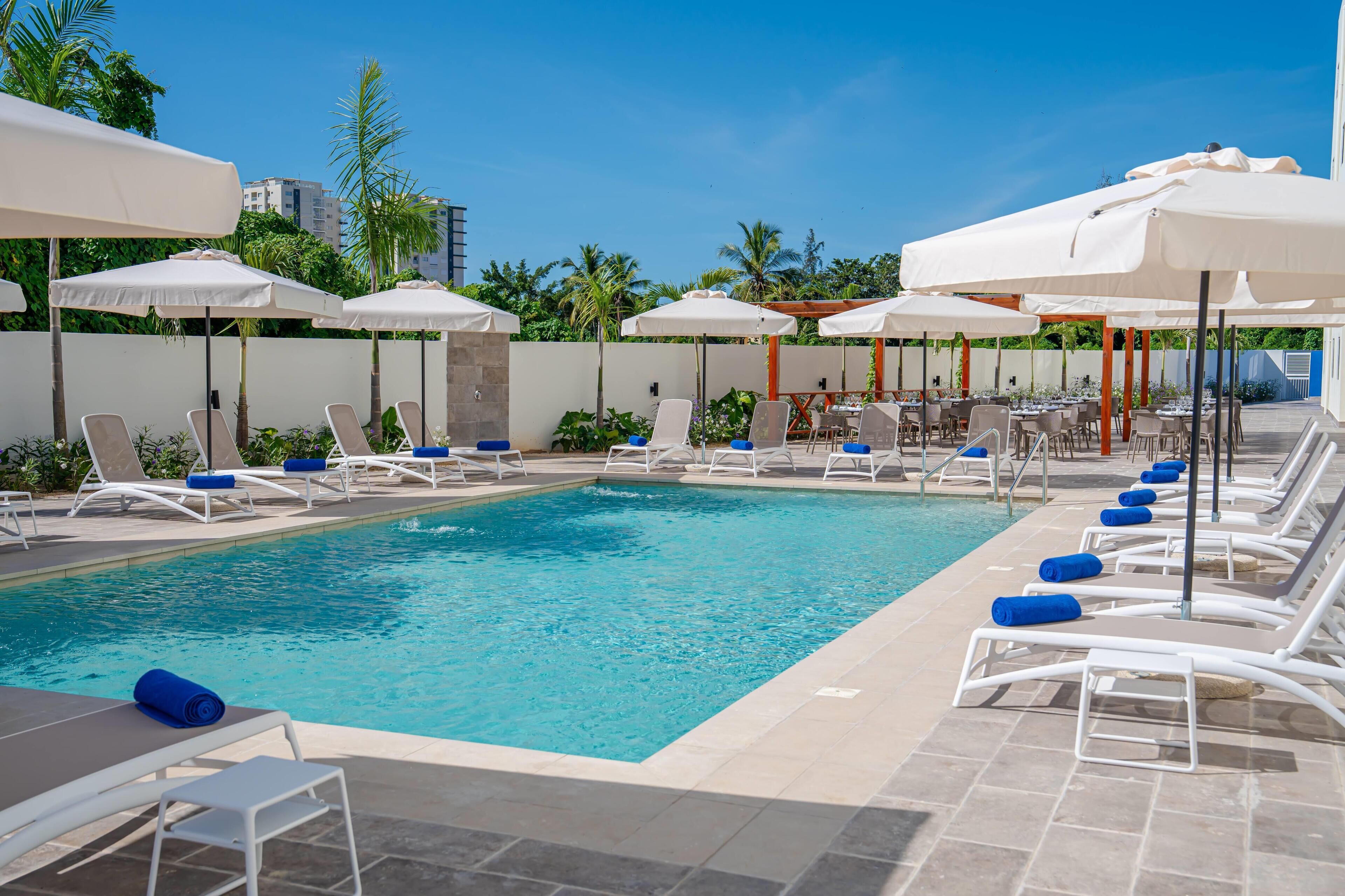Een buitenzwembad, parasols voor strand/zwembad