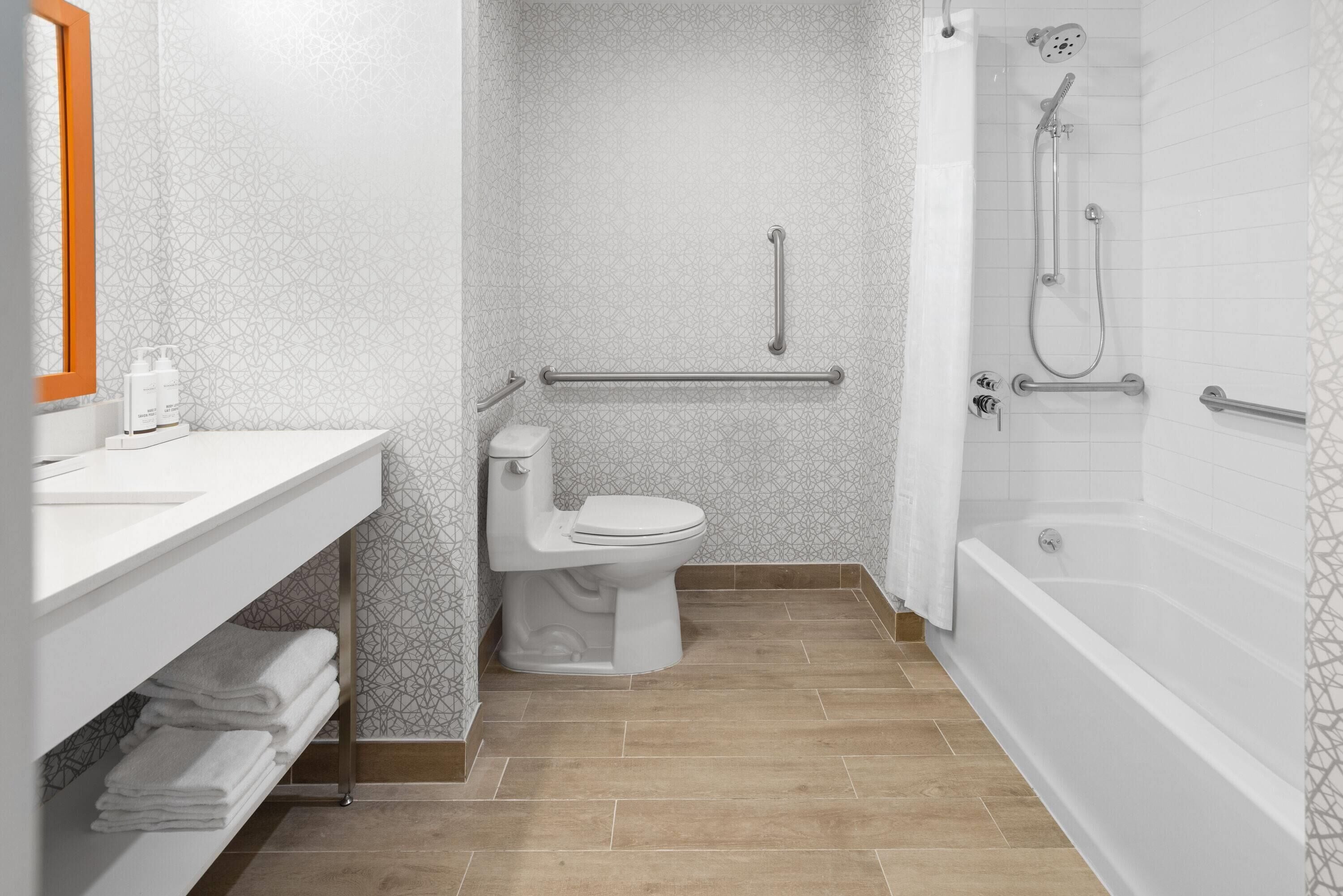 Un baño moderno con inodoro, lavamanos y bañera.