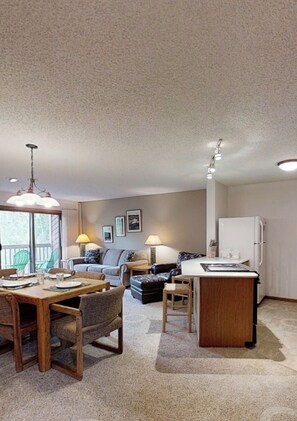 A spacious living area with a dining table, sofa, and a kitchen area with a refrigerator. - Week # 7 February 13th to 20th 2025
2-bedroom condo,Winter Park, Peak Ski Season (Fraser)