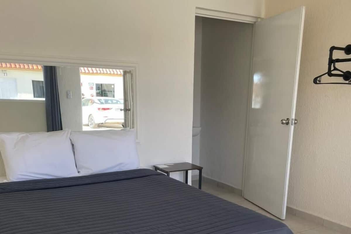 Une chambre à coucher avec un lit, une petite table et une porte.