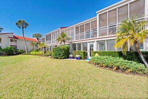 A two-story motel with a red-tiled roof, large windows, and a well-maintained lawn. - Stunning Updated Beachfront Rental on Longboat Key, Close to Ami, Shopping, Dining, and More! (Longboat Key)