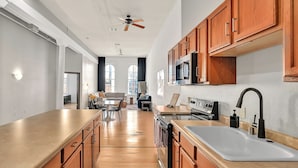 A modern kitchen with wooden cabinets, a large island, and a built-in oven.