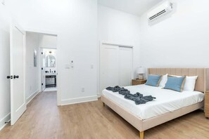 Ein Schlafzimmer mit einem Bett, einem Nachttisch und einer Klimaanlage.