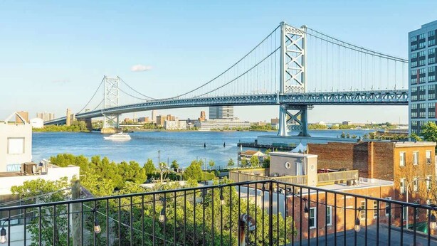 A bridge over a river with buildings in the background. - Luxury Old City - The Heritage (Philadelphia)