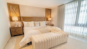 A spacious bedroom with a large bed, two bedside tables, and a bench. - Berthas Collection By EM Hotels (Cartagena)