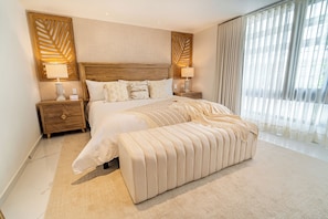 A spacious bedroom with a large bed, two bedside tables, and a bench. - Berthas Collection By EM Hotels (Cartagena)
