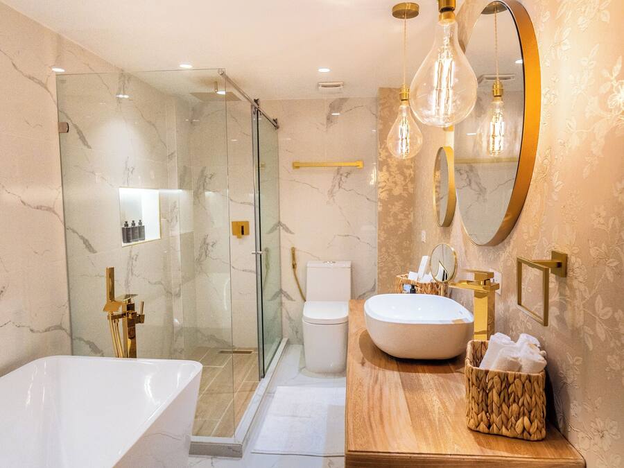 A modern bathroom with a large bathtub, a glass-enclosed shower, and a vanity with a mirror and sink.