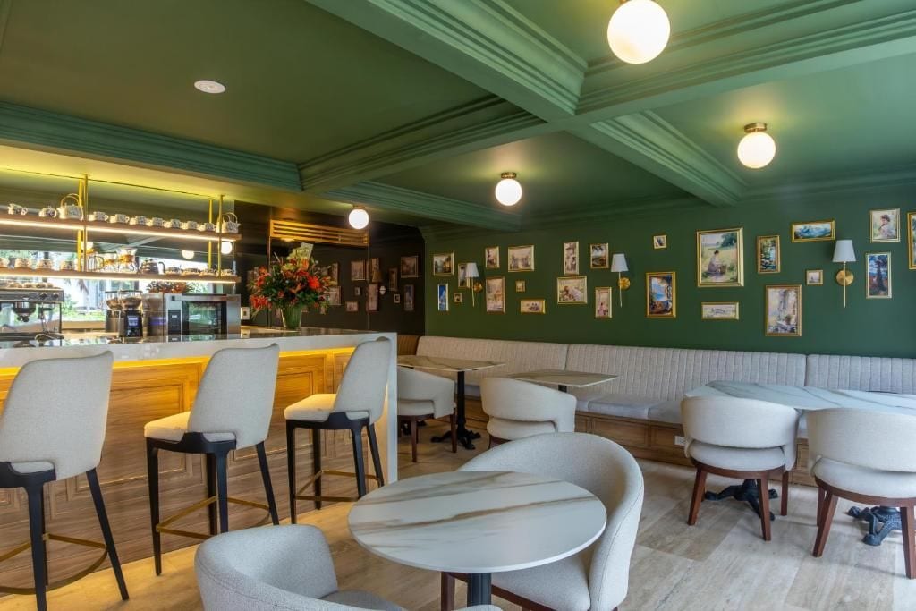 L’intérieur d’un restaurant, avec un bar, des tables et des chaises, et des cadres photos accrochés aux murs.