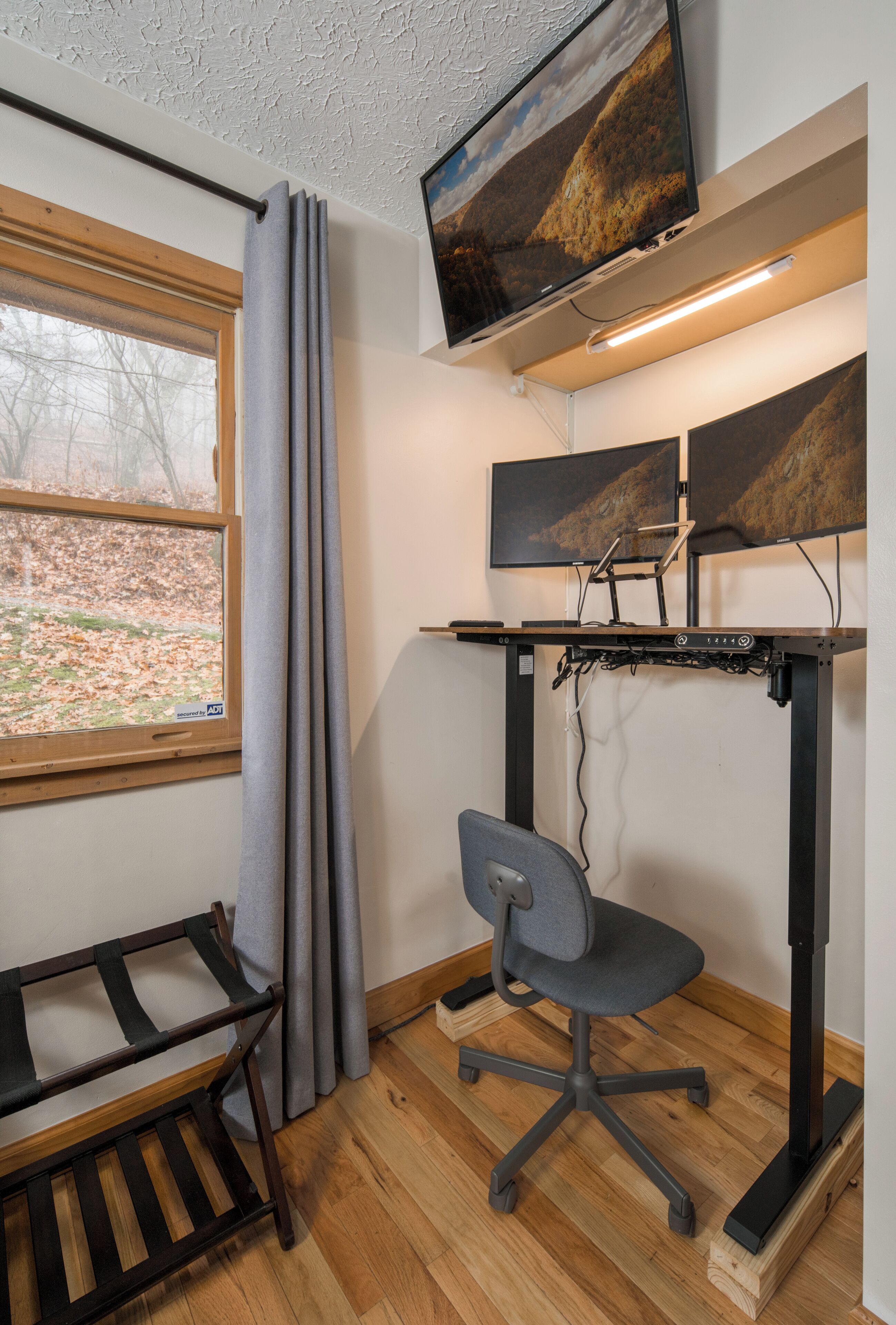 Un espace de bureau moderne comprenant un bureau, une chaise et deux écrans.