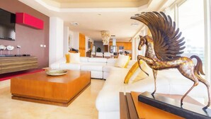 A modern living room with a white sofa, a wooden coffee table, and a decorative horse statue. - Ocean Terrace 3 Habitaciones (Nuevo nayarit)