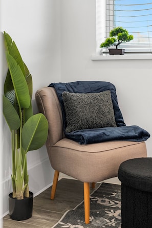 A chair with a dark cushion, a potted plant, and a window with blinds. - Modern | City Stay | Walk to Station| Free Parking (Brighton and Hove)