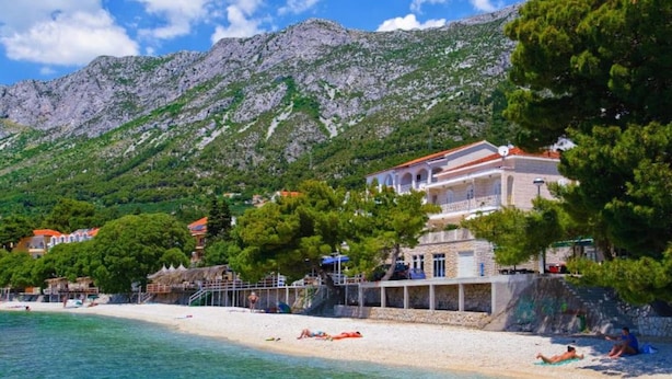 A coastal hotel with a beach, clear waters, and a mountainous backdrop. - Standard Double Room With Private Bathroom 1 (Gradac)