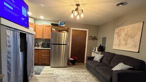 A modern living room with a dark grey sofa, a wooden floor, and a large world map on the wall. - Cozy 1-bedroom apartment in delightful Arlington  (Arlington)