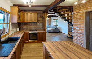A kitchen with wooden cabinets, a black sink, and a built-in oven. - Awesome home in Karlovac with WiFi (Karlovac)