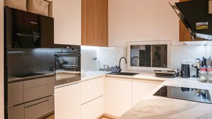 Een moderne keuken met een inbouwoven, een spoelbak en een raam met uitzicht op de ruimte.