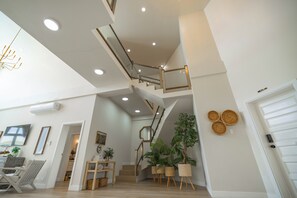 A modern interior with a staircase, wooden flooring, and potted plants. - Styles Beach 2D - Multi Level Ocean View Condo (San Pedro)
