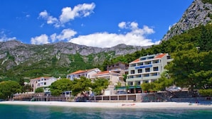 A coastal hotel with multiple buildings, a beach, and mountains in the background. - Standard Double Room With Private Bathroom 2 (Gradac)