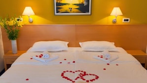 A hotel room with a bed, two bedside lamps, a painting on the wall, and a vase with flowers. - Standard Double Room With Private Bathroom 4 (Gradac)