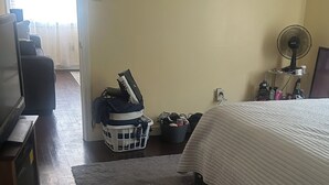 A bedroom with a bed, a TV, a fan, and a laundry basket. - Welcoming 1-bedroom apartment with AC in charming Jackson (Jackson)