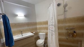 A bathroom with a sink, toilet, shower, and a towel rack. - Appartement vue mer - Hauteurs du Carbet - Kaz des Alizés Au frais - cats allowed (Le Carbet)