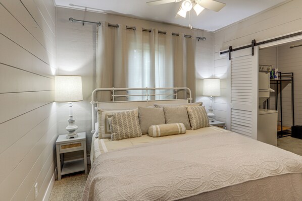 A bedroom with a bed, nightstands, a ceiling fan, and a sliding door leading to a bathroom. - 2 Mi to Dtwn: Charming Sandusky Getaway w/ Hot Tub (Sandusky)