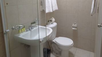 A bathroom with a sink, toilet, and glass shower enclosure.