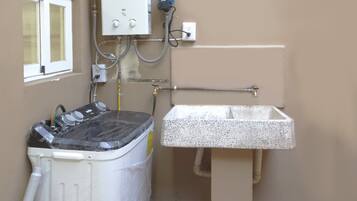 A laundry area with a washing machine, a sink, and a utility panel.