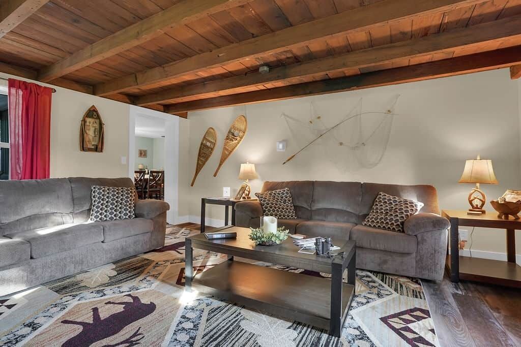 A living room with two sofas, a coffee table, and a wooden ceiling.