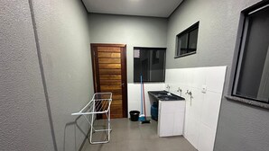 Cuina compacta amb fornet integrat, un rentapeus i una finestra sobre la tauleta.