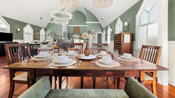 Comedor con una mesa de madera dispuesta para seis personas, rodeado de sillas.