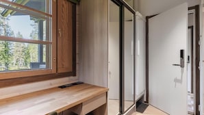Cuina moderna amb taulell de fusta, una porta corredissa de vidre que dona a un balcó i una porta blanca a la dreta.