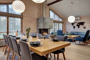 Un interior moderno con una mesa de comedor de madera dispuesta para cuatro personas, rodeada de sillas tapizadas en gris.