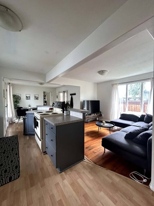 A spacious living area with a kitchen, a sofa, and a TV.
