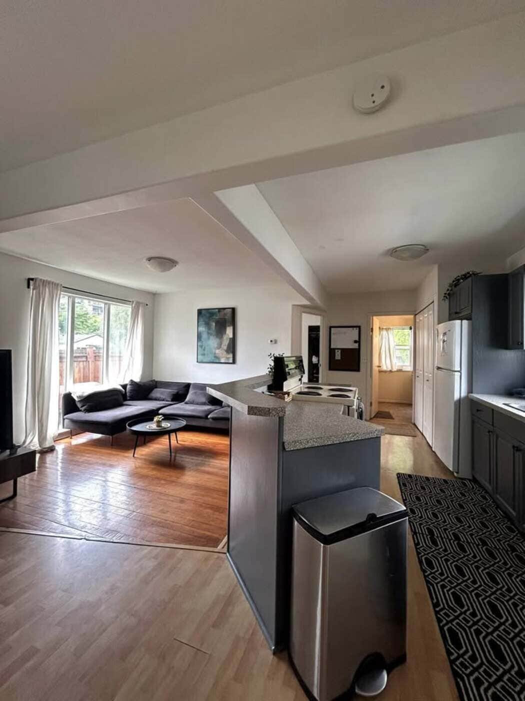 Un espacio de estar moderno con cocina, comedor y zona de estar con sofá y mesa de centro.