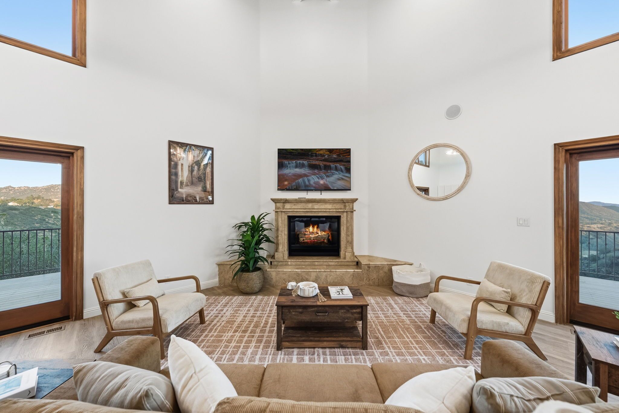 Una sala de estar con chimenea, dos sillones, un sofá y una mesa de centro.