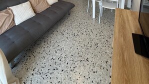 Een knus woongedeelte met een bank, een eettafel en een kitchenette.