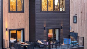 A modern building with a mix of wooden and dark panel exteriors, large windows, and outdoor seating areas. - Smoky Mountain Cabin With Indoor Pool + Hot Tub + Views Dolly's Dreamhouse by Avantstay (Sevierville)